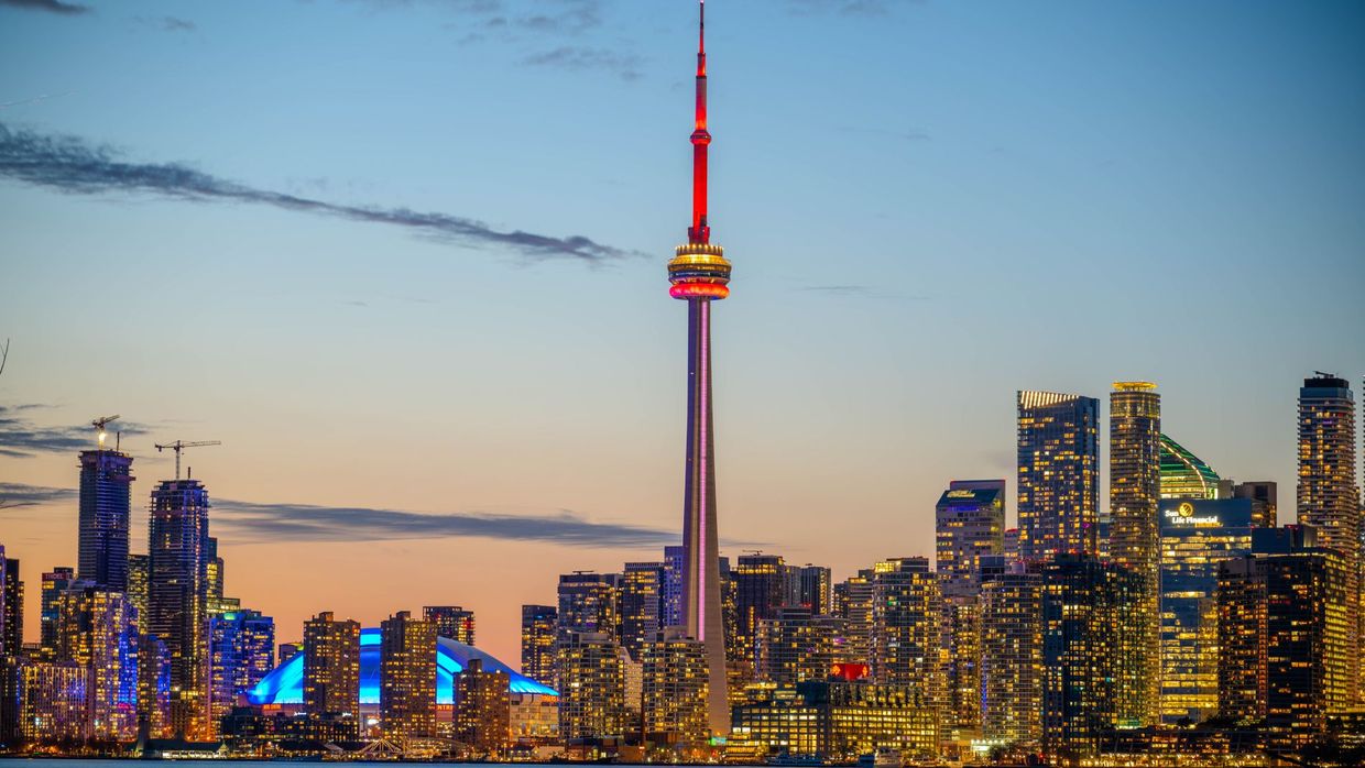 SEO salaries in Canada: beautiful sunset view of Toronto skyline with CN Tower and city lights reflecting on the lake