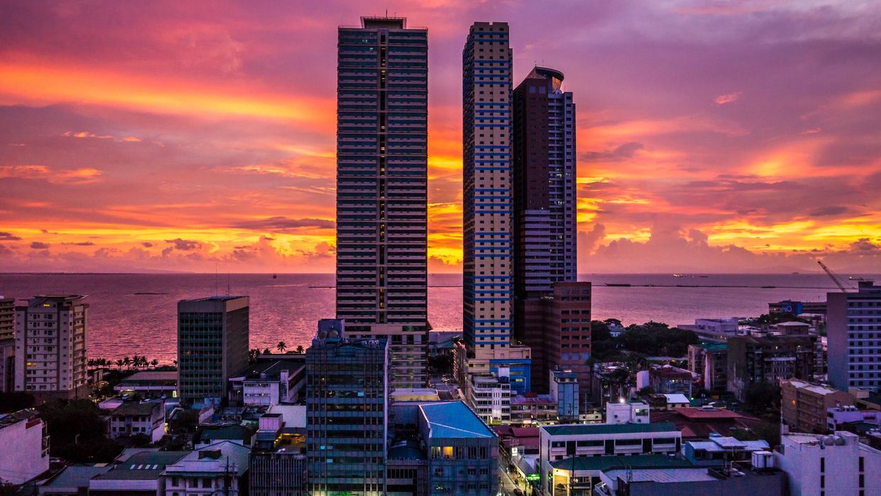 SEO salaries in the Philippines: stunning cityscape of Manila skyscrapers during a colorful sunset with sea view